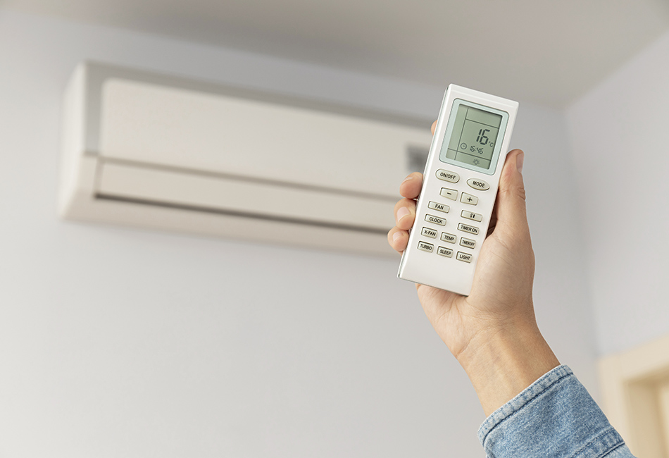 Climaestrat, tus especialistas en las Instalaciones Frigoríficas y de Climatización en Vinaròs / Vinaroz. Control remoto de mano femenino desde el aire acondicionado.